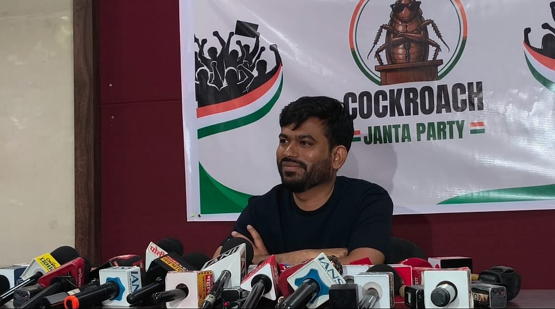 Abhijeet Dipke seated at a press conference in front of a Cockroach Janta Party banner